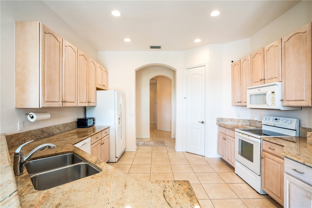 4565 Bridgepointe Way, Unit 142 Vero Beach, FL 32967 - Photo 15 of 36 a kitchen with stainless steel appliances granite countertop a sink a stove and cabinets