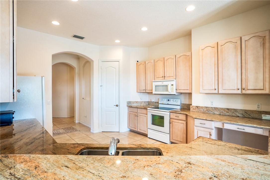 4565 Bridgepointe Way, Unit 142 Vero Beach, FL 32967 - Photo 17 of 36 a kitchen with stainless steel appliances granite countertop a refrigerator sink and cabinets