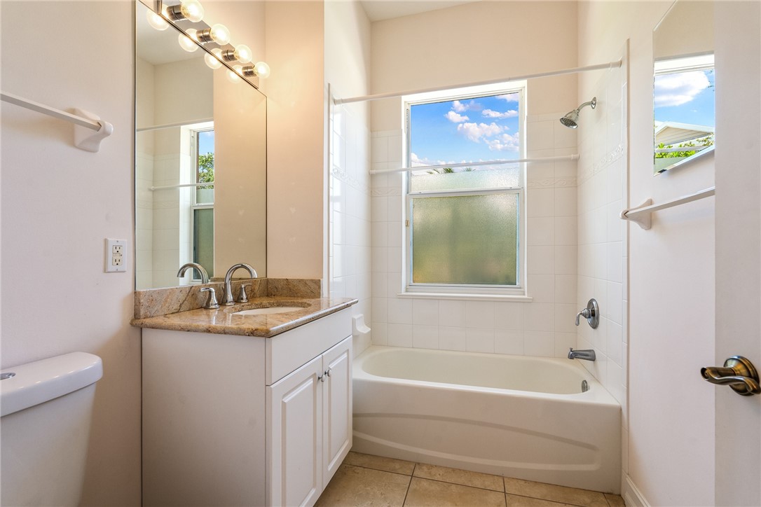 4565 Bridgepointe Way, Unit 142 Vero Beach, FL 32967 - Photo 26 of 36 a bathroom with a granite countertop sink toilet and shower