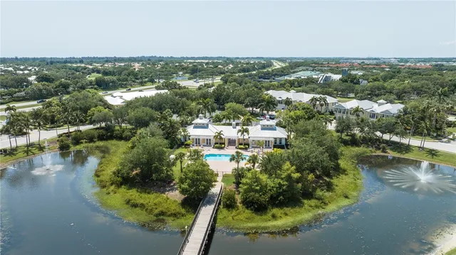 an aerial view of residential houses with outdoor space and lake view