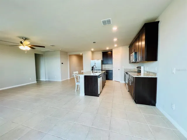 an empty room with windows and ceiling fan