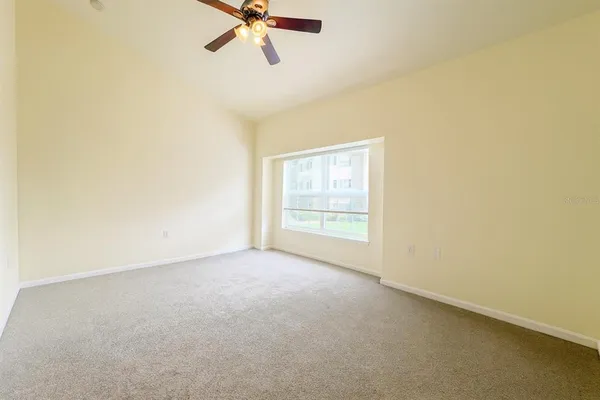 an empty room with a window and a fan