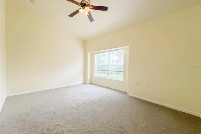an empty room with a window and a fan