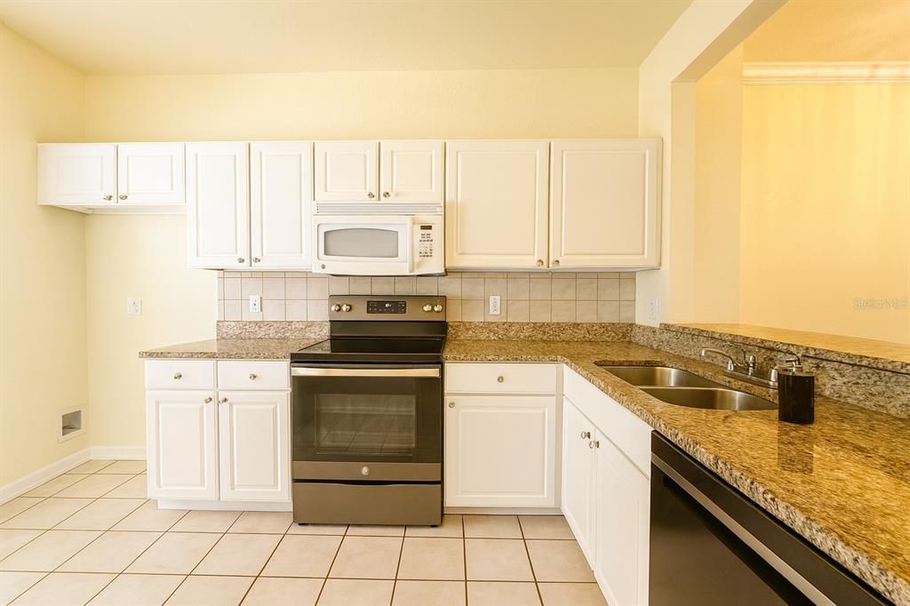 4877 Northwest 42nd Road, Unit 106 Gainesville, FL 32606 - Photo 2 of 27 a kitchen with a sink stove and cabinets