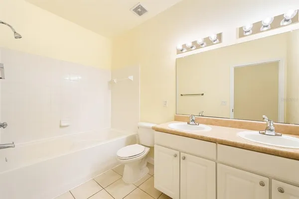 a bathroom with a granite countertop sink a toilet and bathtub