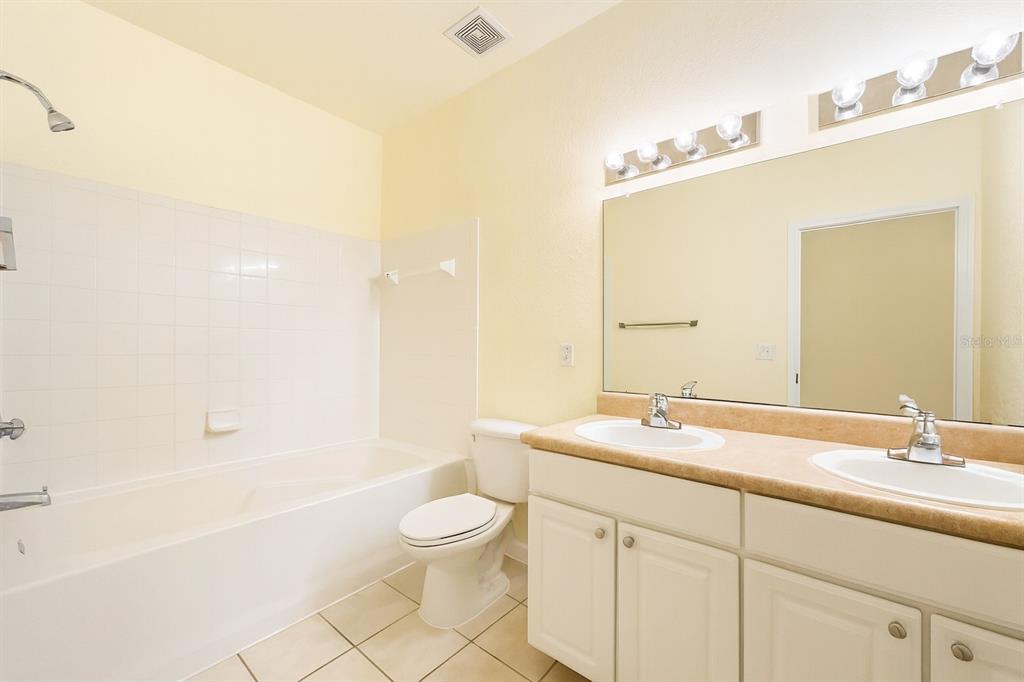 4877 Northwest 42nd Road, Unit 106 Gainesville, FL 32606 - Photo 22 of 27 a bathroom with a granite countertop sink a toilet and bathtub