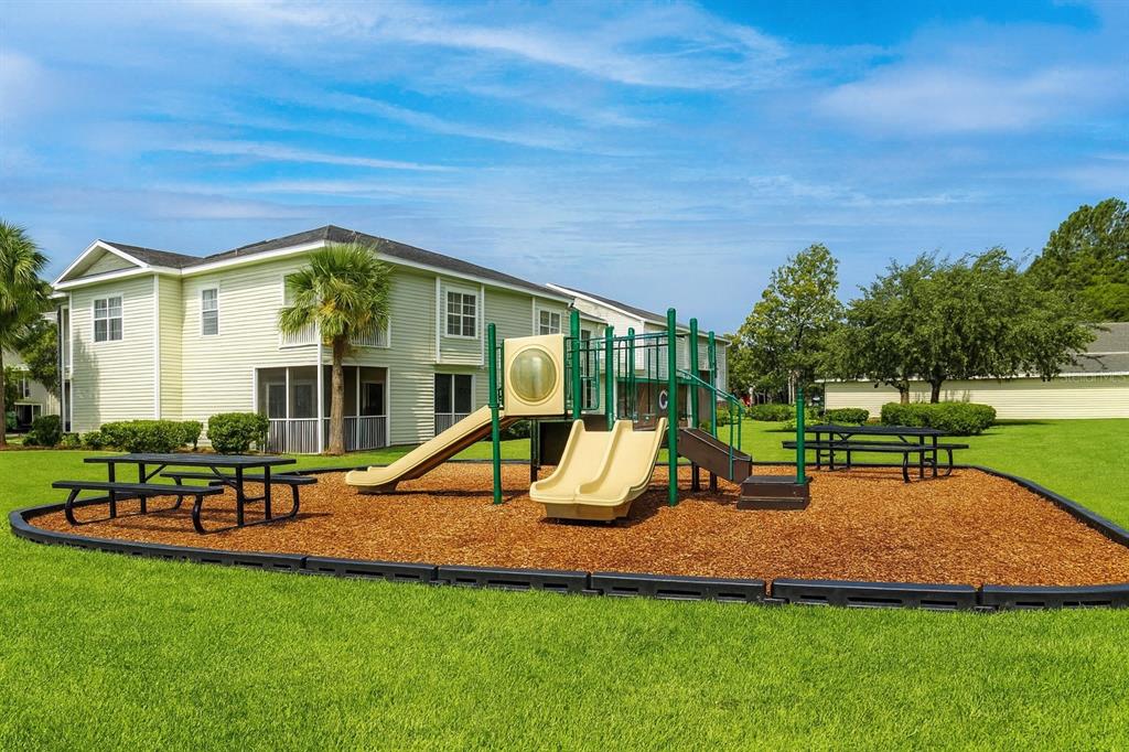 4877 Northwest 42nd Road, Unit 106 Gainesville, FL 32606 - Photo 26 of 27 a view of a house with a yard table and chairs