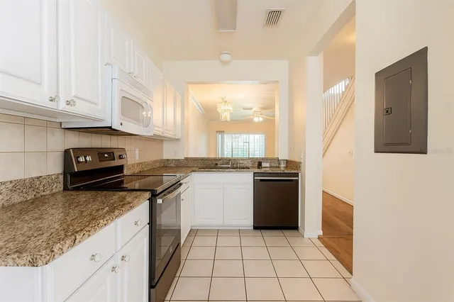 a kitchen with a sink a stove and cabinets