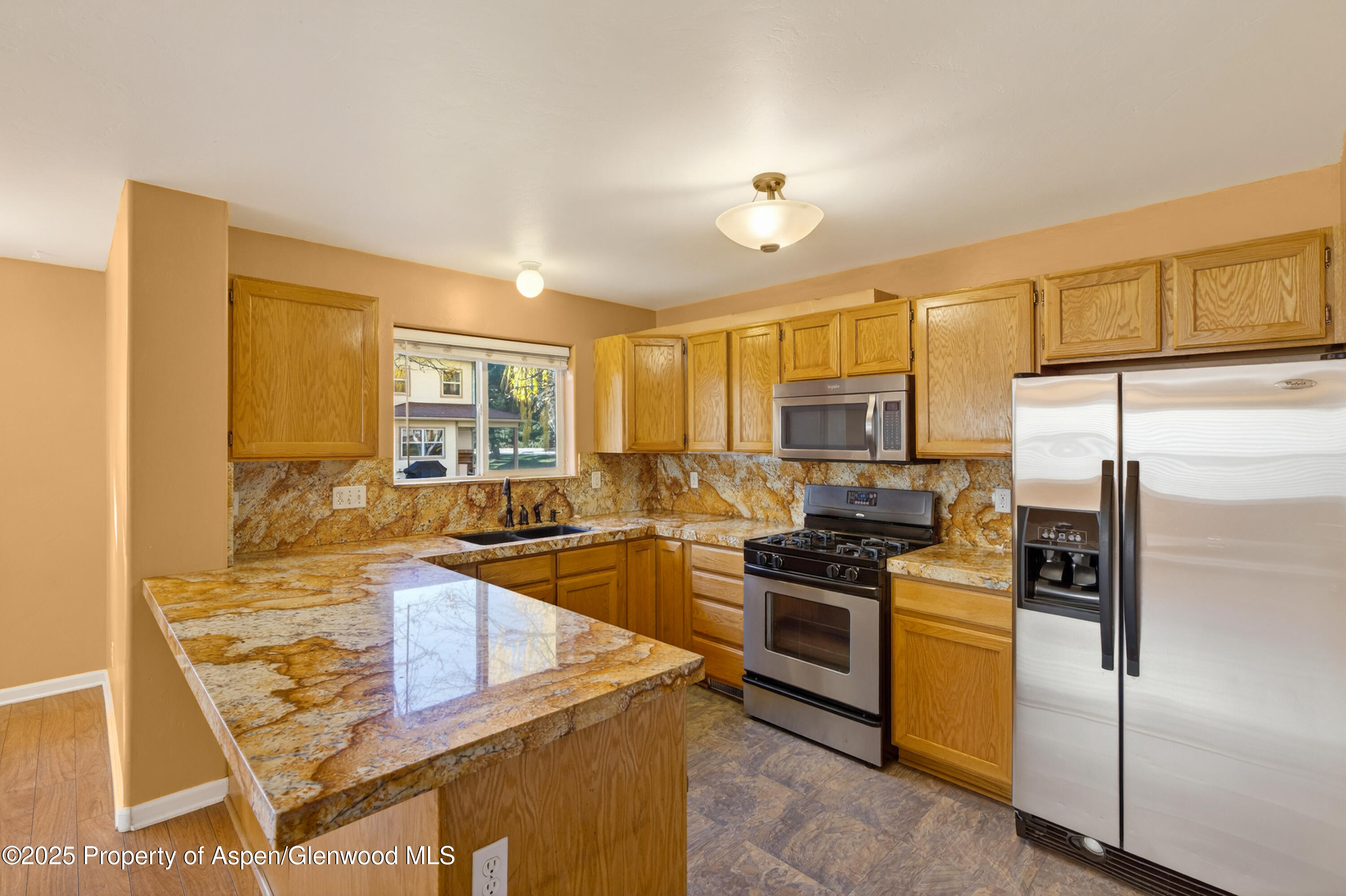830 Donegan Road, Unit D Glenwood Springs, CO 81601 - Photo 4 of 21 a kitchen with stainless steel appliances granite countertop a sink stove and refrigerator