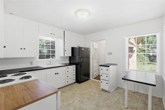 a kitchen with granite countertop a refrigerator stove top oven and sink