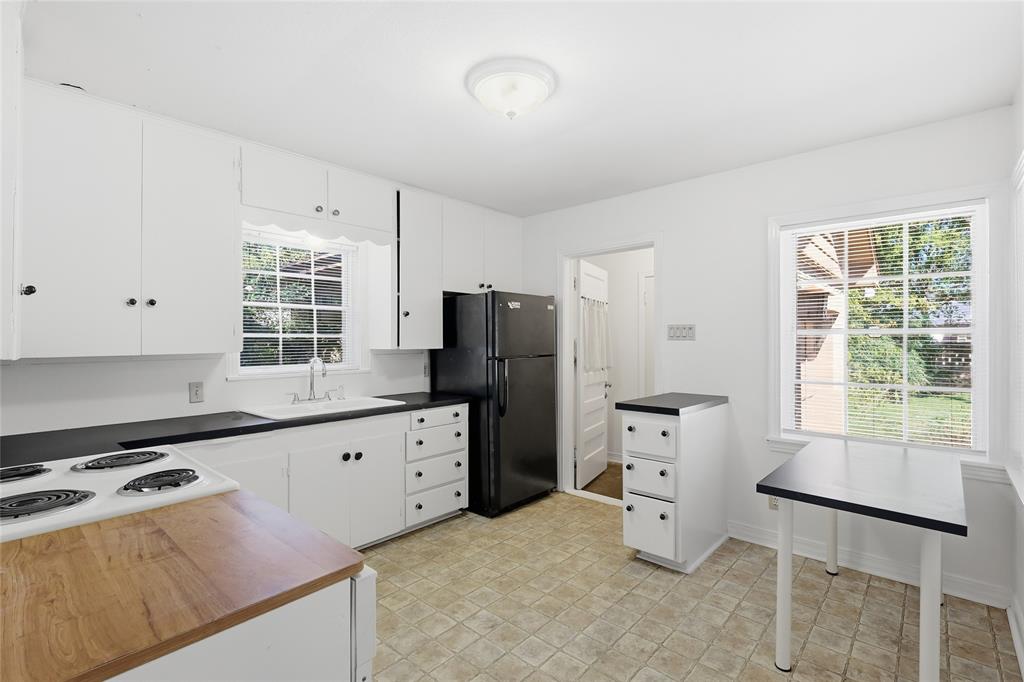 1822 West Hickory Street Denton, TX 76201 - Photo 11 of 20 a kitchen with granite countertop a refrigerator stove top oven and sink