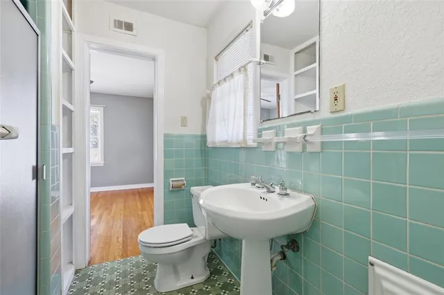 a bathroom with a sink toilet and mirror