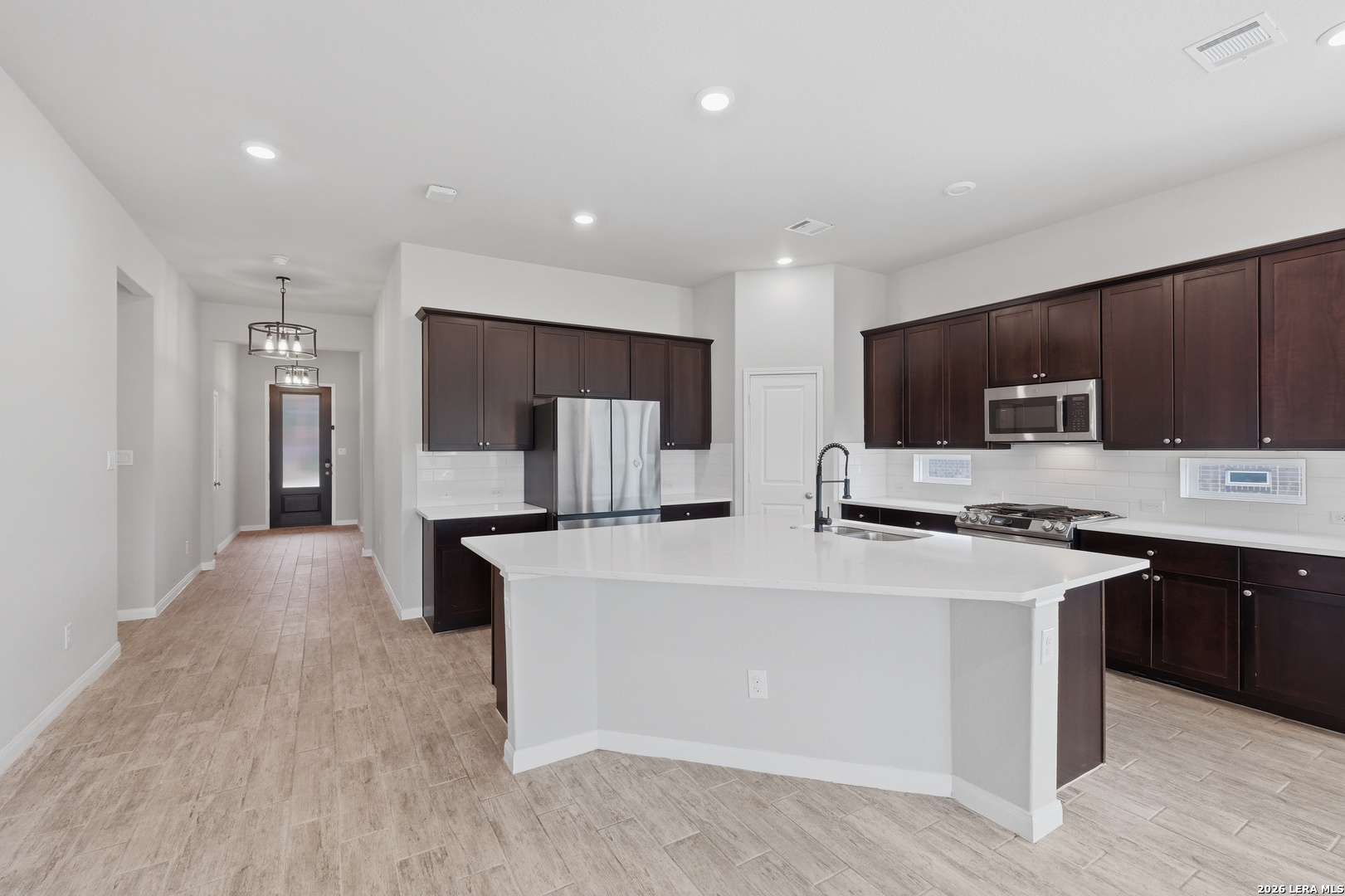 32125 Cardamom Way Bulverde, TX 78163 - Photo 11 of 32 a large kitchen with stainless steel appliances a sink a stove a refrigerator and cabinets