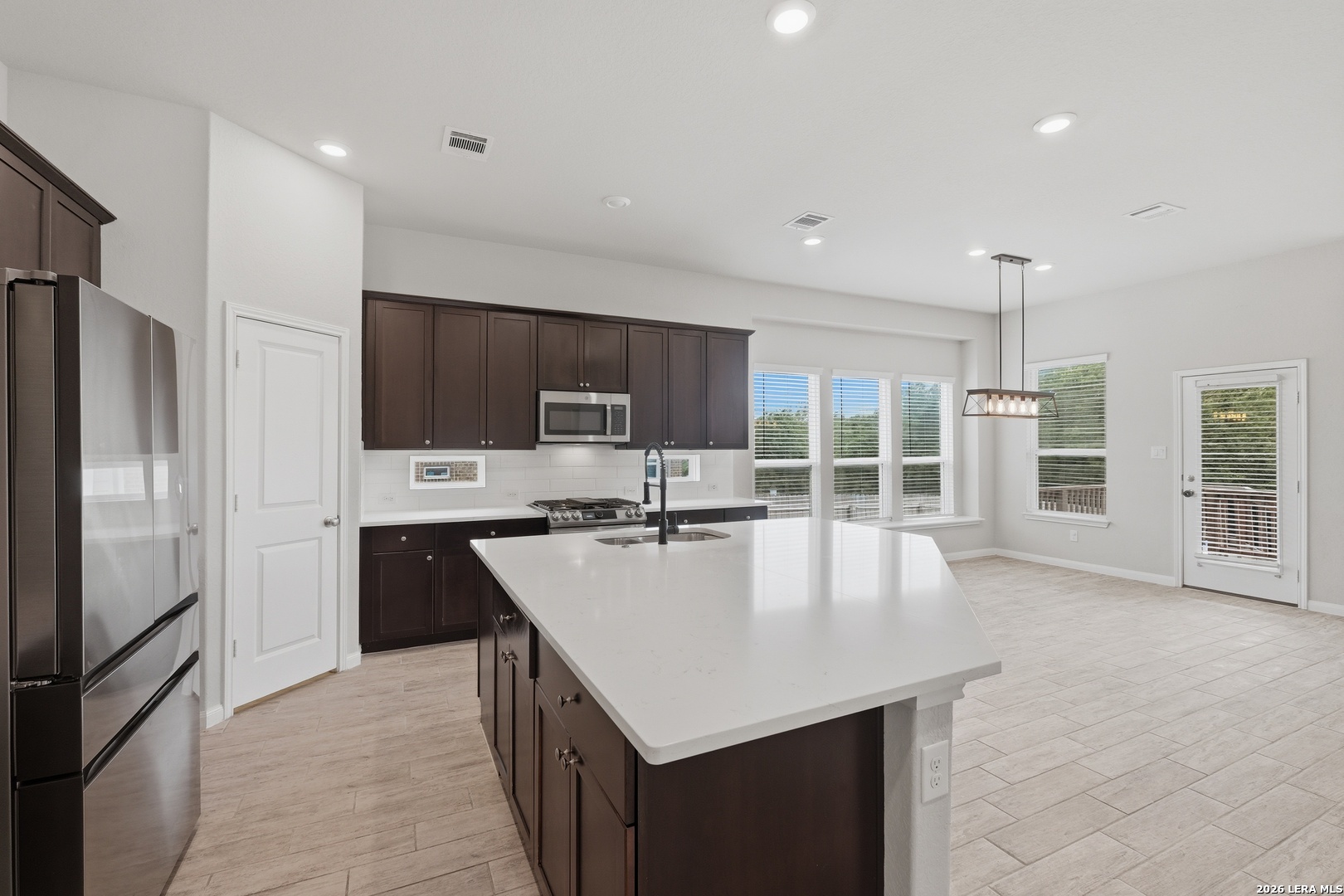 32125 Cardamom Way Bulverde, TX 78163 - Photo 8 of 32 a large kitchen with kitchen island a large counter top stainless steel appliances and cabinets