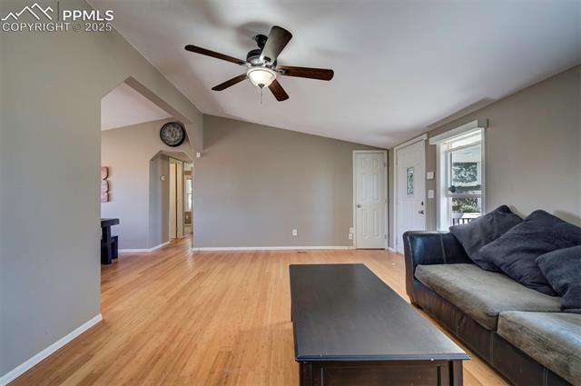 5860 Curtis Road Peyton, CO 80831 - Photo 7 of 28 Living area with lofted ceiling, baseboards, light wood-type flooring, and a ceiling fan