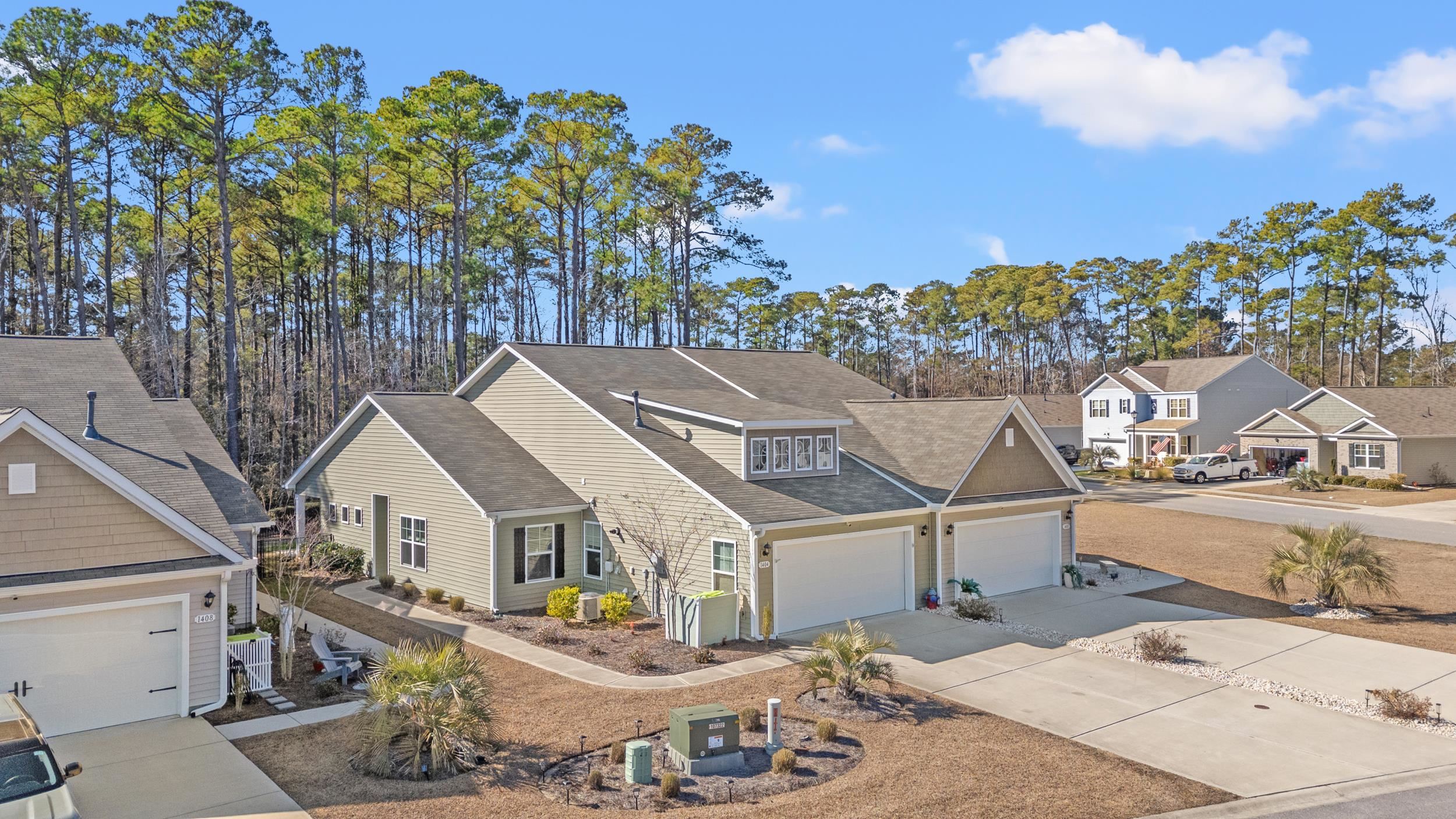 Traditional-style home with a shingled roof, concrete driveway, an attached garage, and a residential view