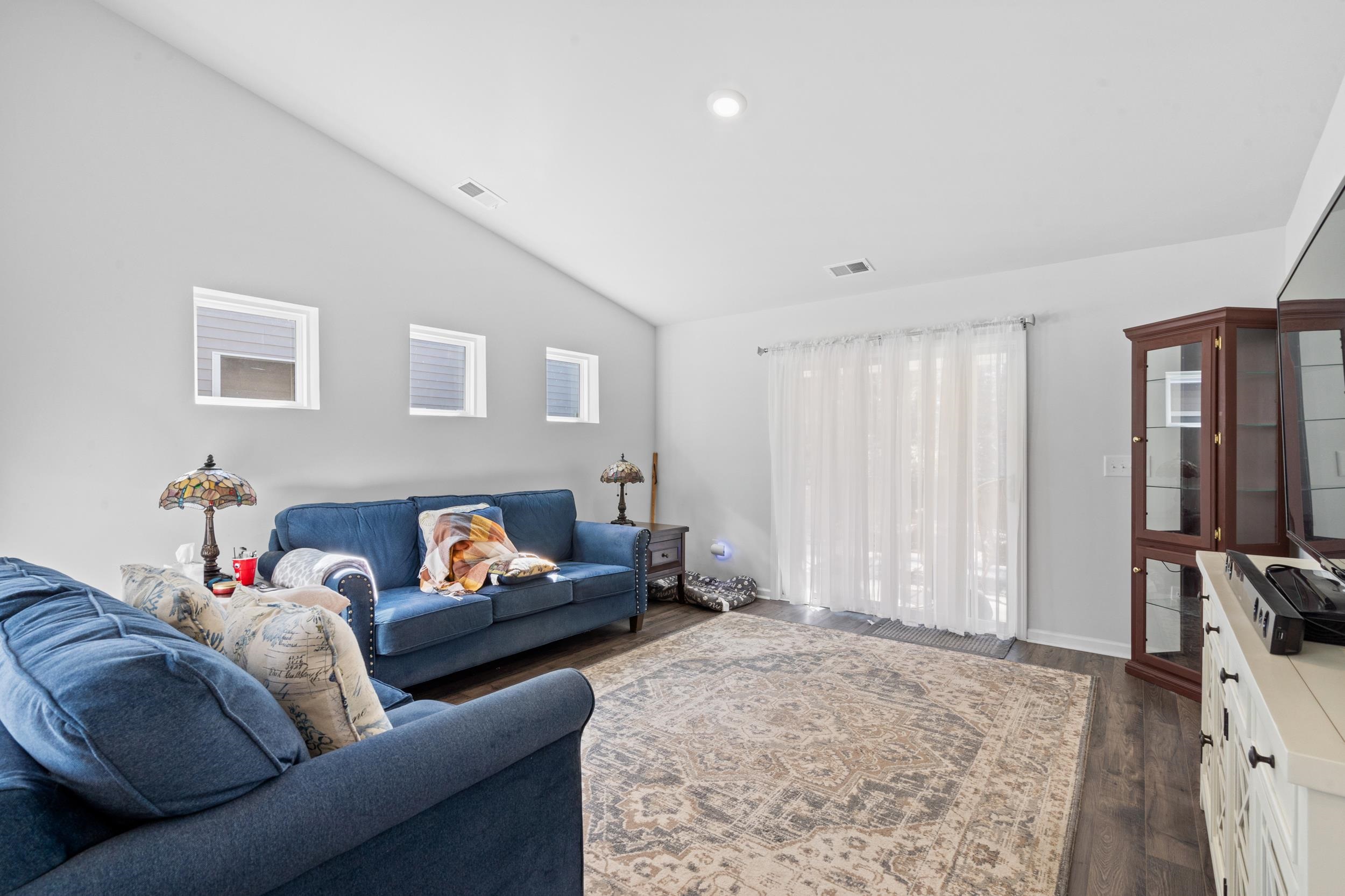 1404 Jardine Loop Little River, SC 29566 - Photo 13 of 31 Living area with high vaulted ceiling and dark wood-type flooring
