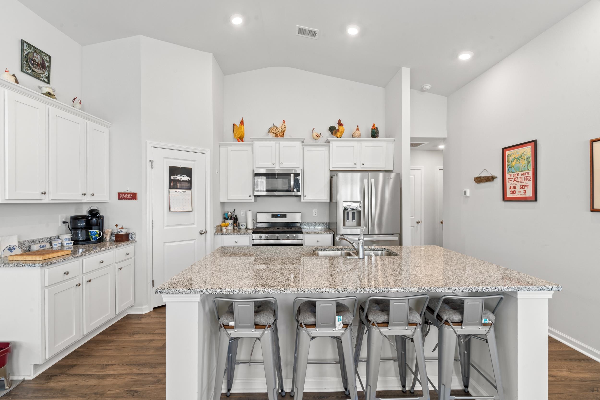 1404 Jardine Loop Little River, SC 29566 - Photo 21 of 31 Kitchen with dark wood-type flooring, white cabinetry, appliances with stainless steel finishes, a kitchen island with sink, and vaulted ceiling