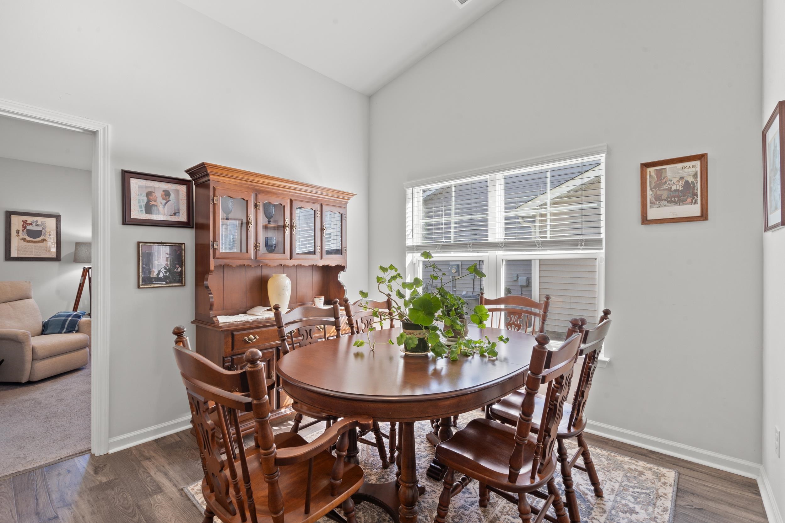 1404 Jardine Loop Little River, SC 29566 - Photo 23 of 31 Kitchen featuring a breakfast bar area, white cabinetry, stainless steel appliances, light stone countertops, and dark wood finished floors