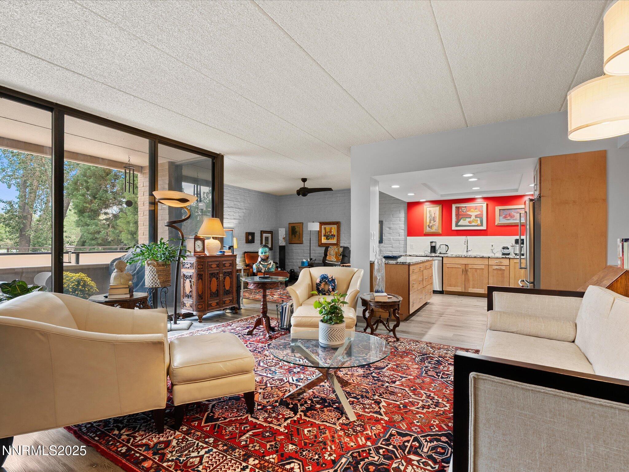 1200 Riverside Drive, Unit 1276 Reno, NV 89503 - Photo 14 of 47 a living room with furniture a rug and a floor to ceiling window