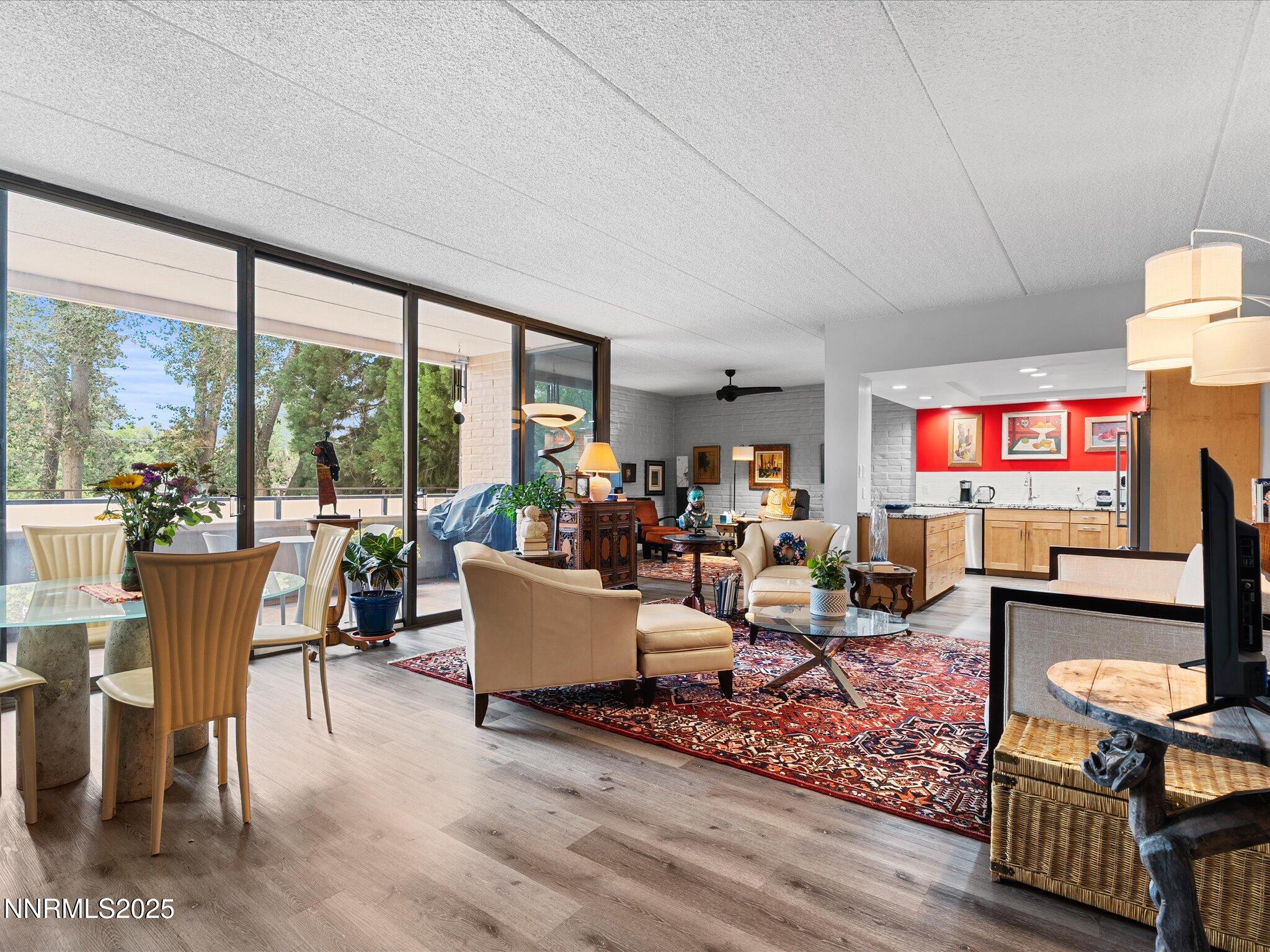 1200 Riverside Drive, Unit 1276 Reno, NV 89503 - Photo 2 of 47 a living room with furniture a flat screen tv and a floor to ceiling window