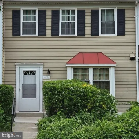 a view of a house with large windows and a yard