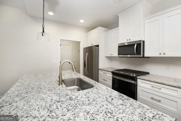 a kitchen with stainless steel appliances granite countertop a sink stove and refrigerator