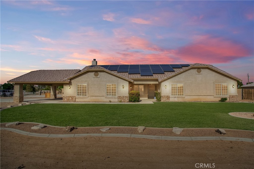 a view of a big house with a big yard and potted plants