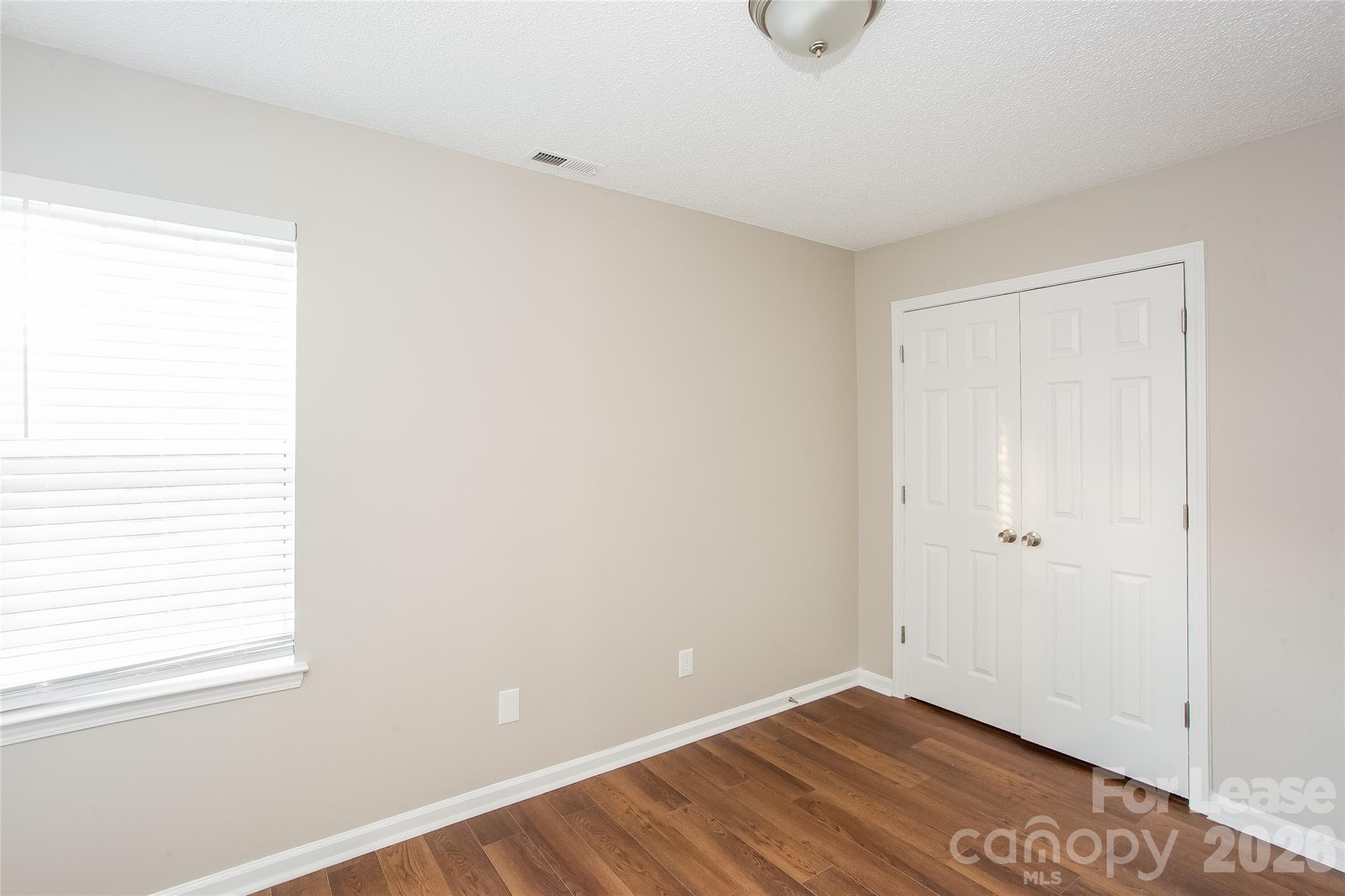 4262 Barley Street Southwest Concord, NC 28027 - Photo 12 of 15 a view of an empty room with wooden floor and a window