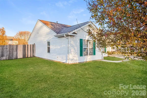 a view of a house with backyard and a tree