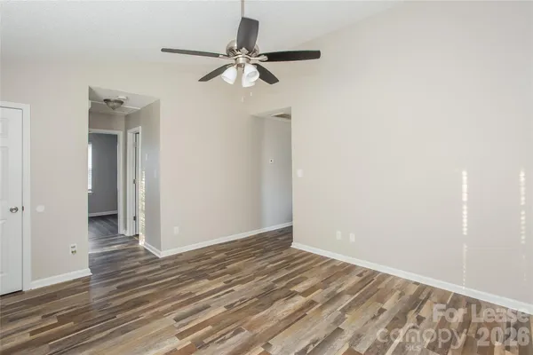 a view of a room with wooden floor and a ceiling fan