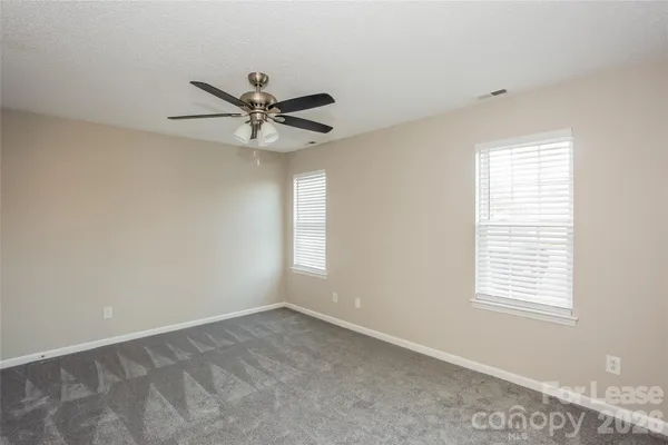 a view of a workspace with a window and a ceiling fan