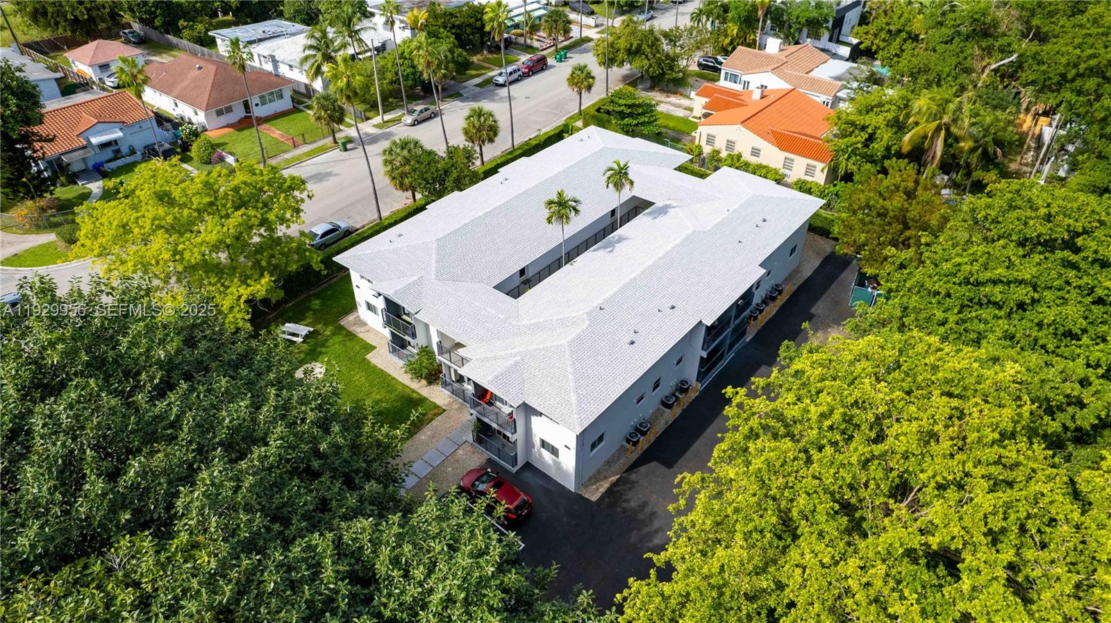 an aerial view of a house with a yard and large trees