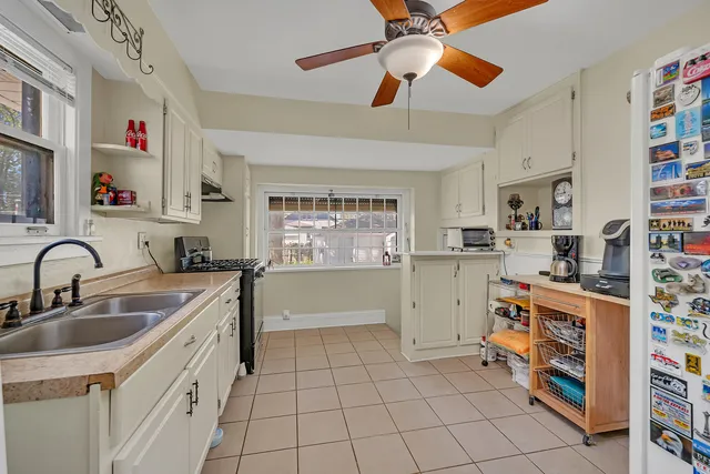 a kitchen with stainless steel appliances a sink cabinets and a window