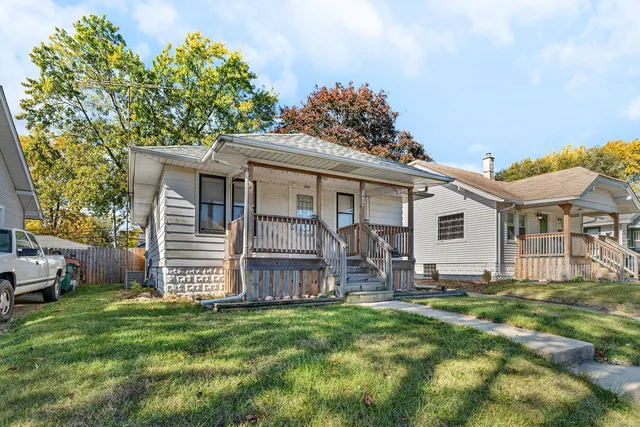 a view of a house with a yard and sitting area