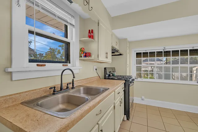 a kitchen with a sink cabinets and a stove top oven