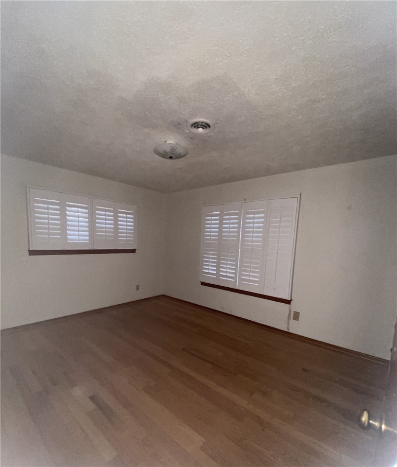1119 Jefferson Street Alice, TX 78332 - Photo 12 of 23 an empty room with wooden floor and windows