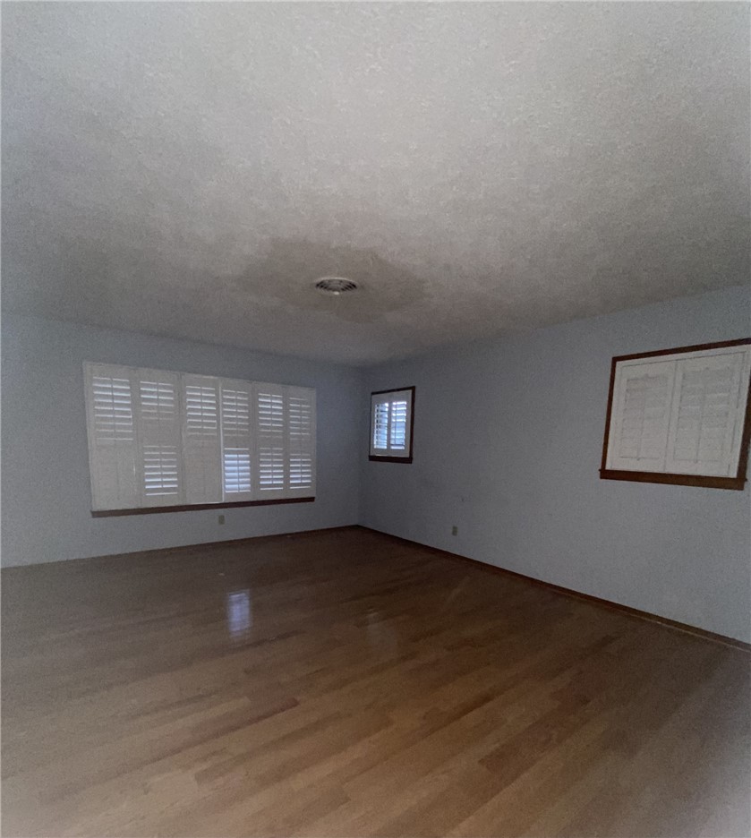 1119 Jefferson Street Alice, TX 78332 - Photo 4 of 23 an empty room with wooden floor and windows