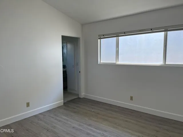 a view of small space with wooden floor and a window