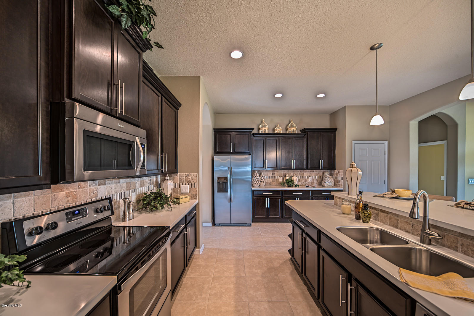 4082 Ruthann Circle Melbourne, FL 32934 - Photo 6 of 13 a kitchen with stainless steel appliances granite countertop a stove a sink and a refrigerator