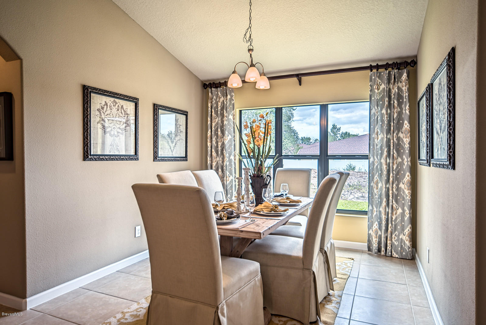 4082 Ruthann Circle Melbourne, FL 32934 - Photo 8 of 13 a dining room with furniture a chandelier and wooden floor