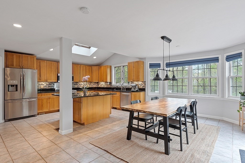 176 Southville Road Southborough, MA 01772 - Photo 11 of 39 a kitchen with stainless steel appliances kitchen island granite countertop a table chairs sink and stove