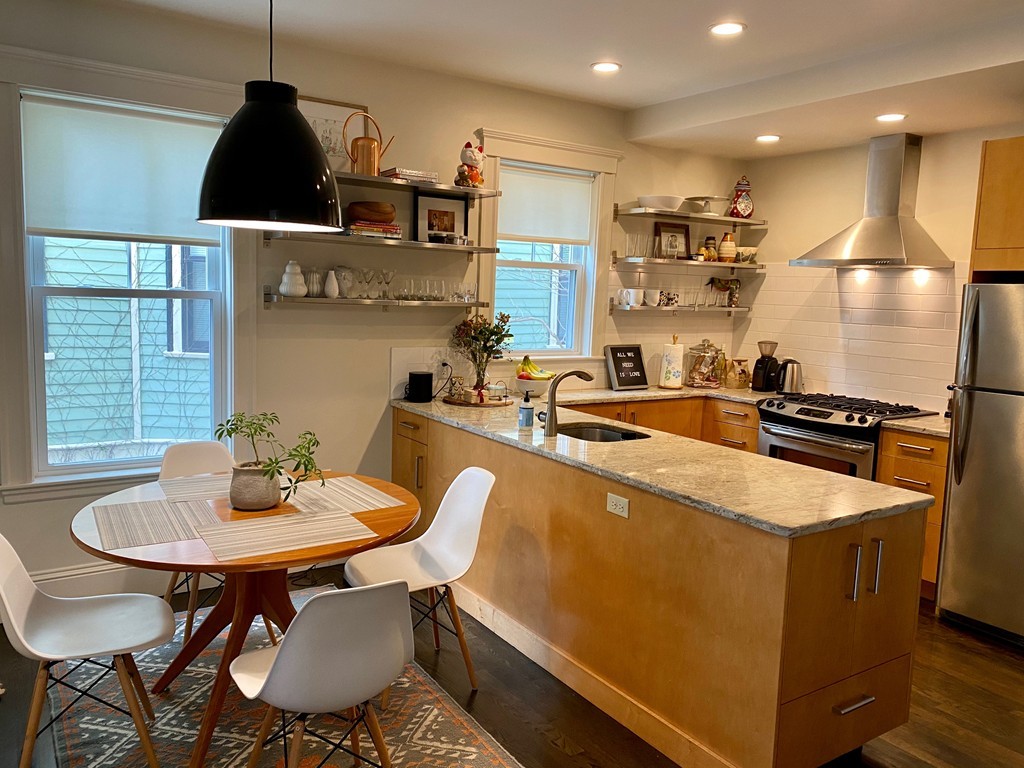 a kitchen with a dining table chairs and white cabinets