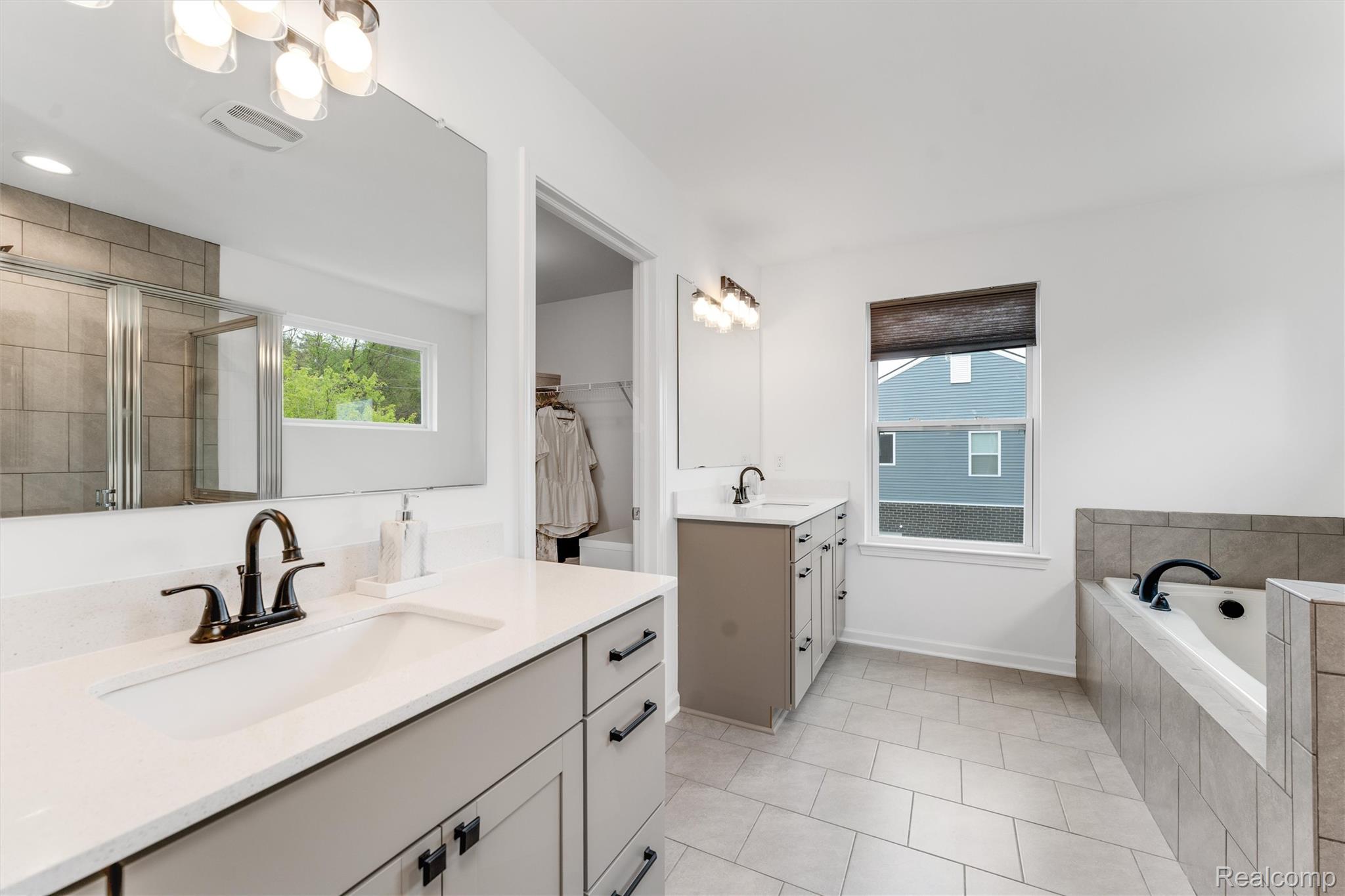 908 South Livernois Road Rochester, MI 48309 - Photo 26 of 49 Full bath featuring two vanities, a stall shower, hanging lights, a bath, and a spacious closet