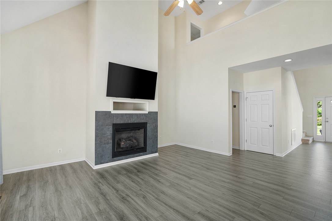 225 Streams Way Anderson, SC 29625 - Photo 13 of 50 The living room features high ceilings and a modern fireplace, creating an inviting and comfortable atmosphere.
