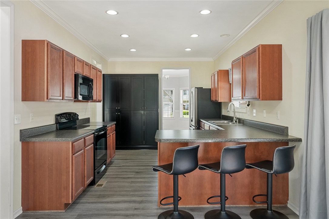 225 Streams Way Anderson, SC 29625 - Photo 16 of 50 This modern kitchen features a breakfast bar, ample cabinetry, and sleek appliances.