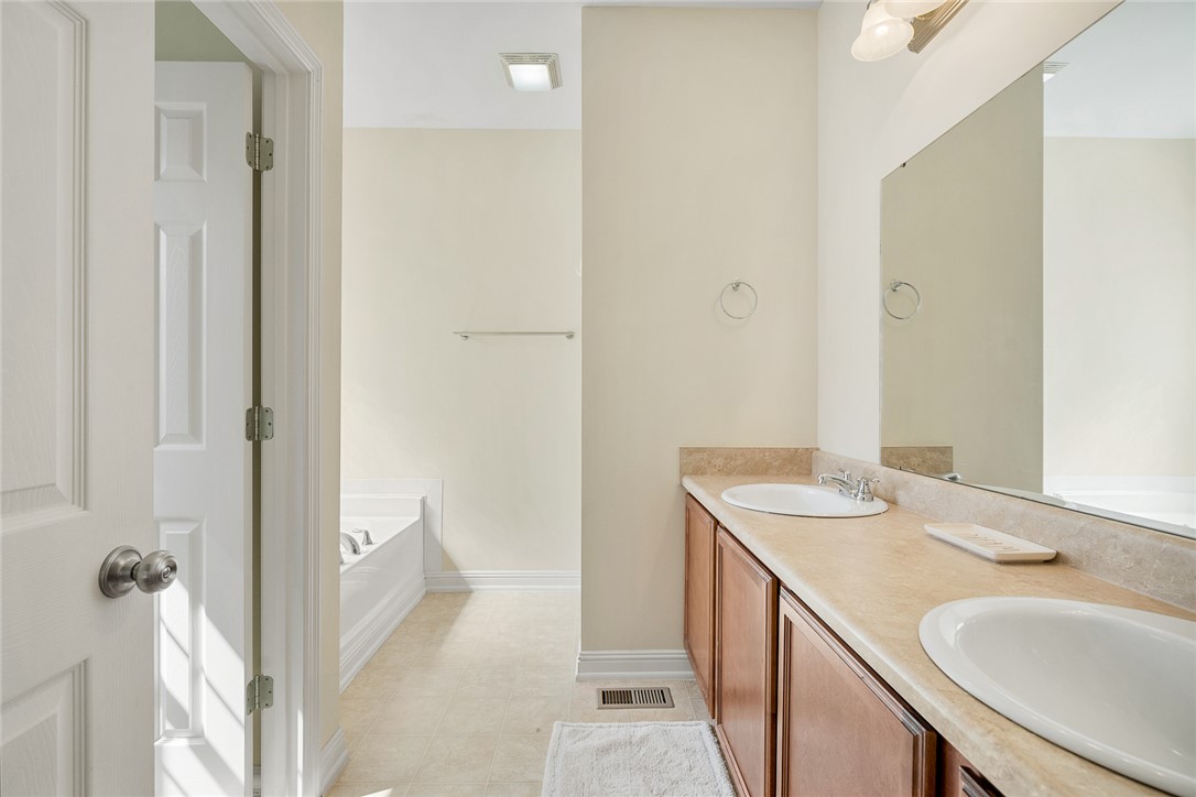 225 Streams Way Anderson, SC 29625 - Photo 27 of 50 This bright bathroom offers dual sinks, a large mirror, and a spacious tub, creating a comfortable and practical space.