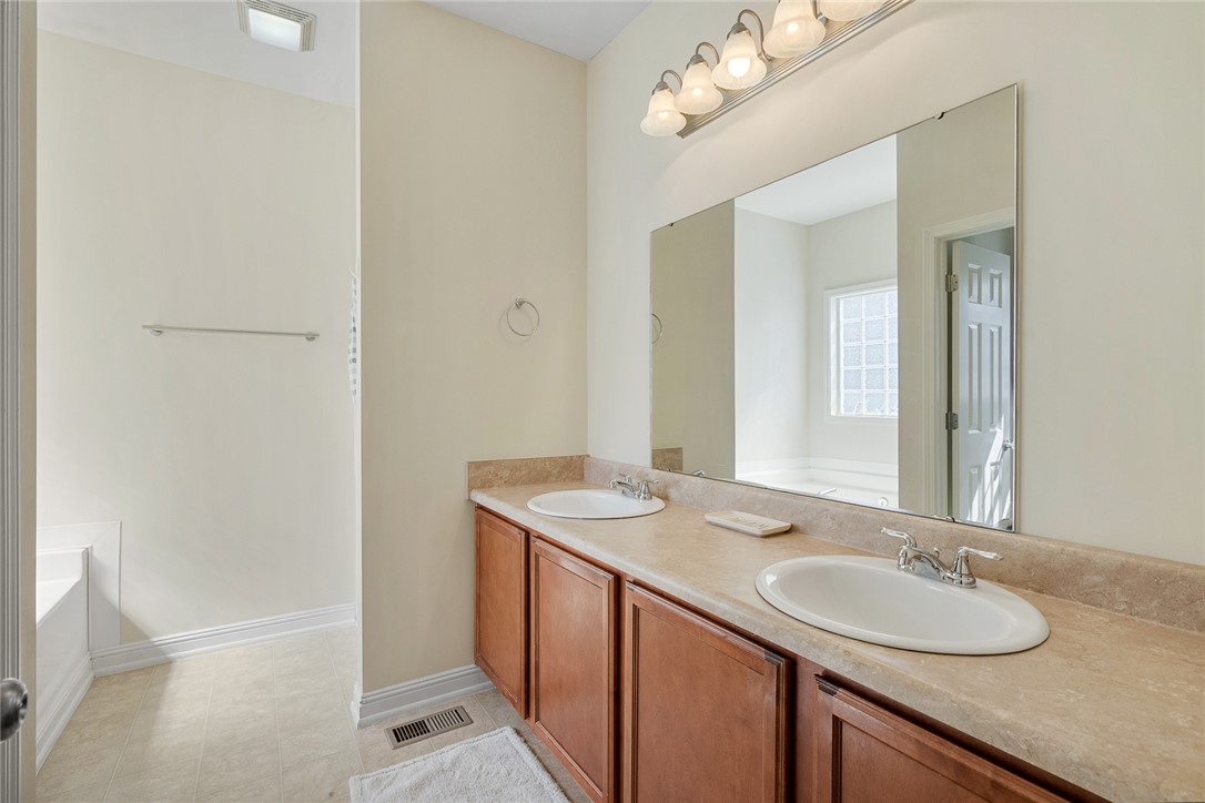 225 Streams Way Anderson, SC 29625 - Photo 28 of 50 This primary bathroom offers dual sinks, ample counter space, and a separate tub area.