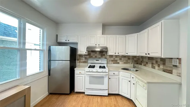 a kitchen with a white cabinets and white appliances