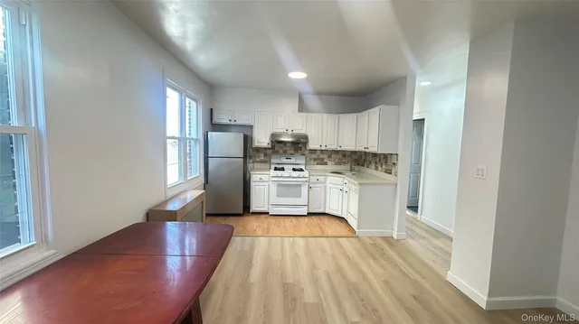 a kitchen with a refrigerator a sink dishwasher with a dining table and chairs